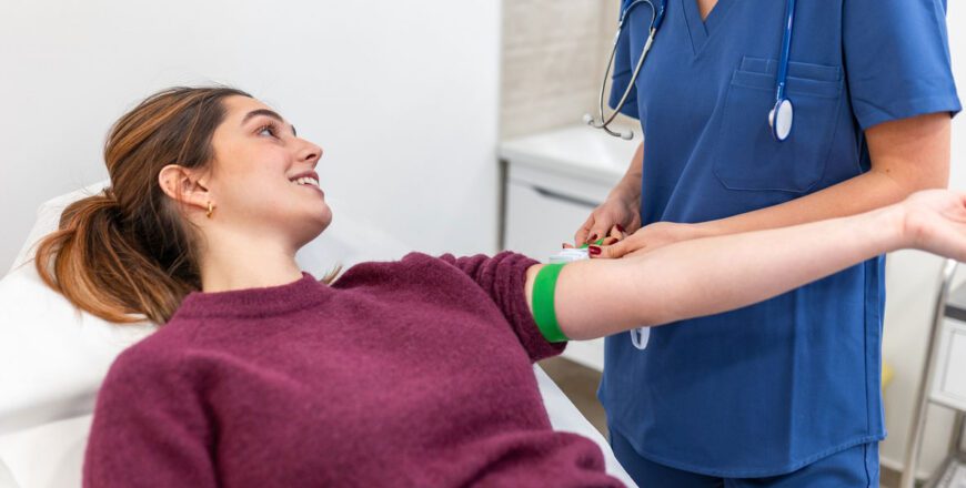 nurse-in-scrubs-preparing-a-seated-patient's-arm-for-a-blood-draw