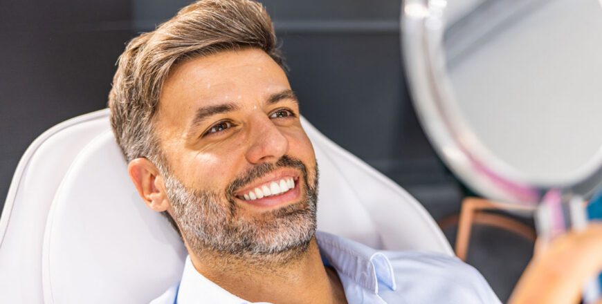smiling-man-looking-at-his-reflection-in-a-handheld-mirror