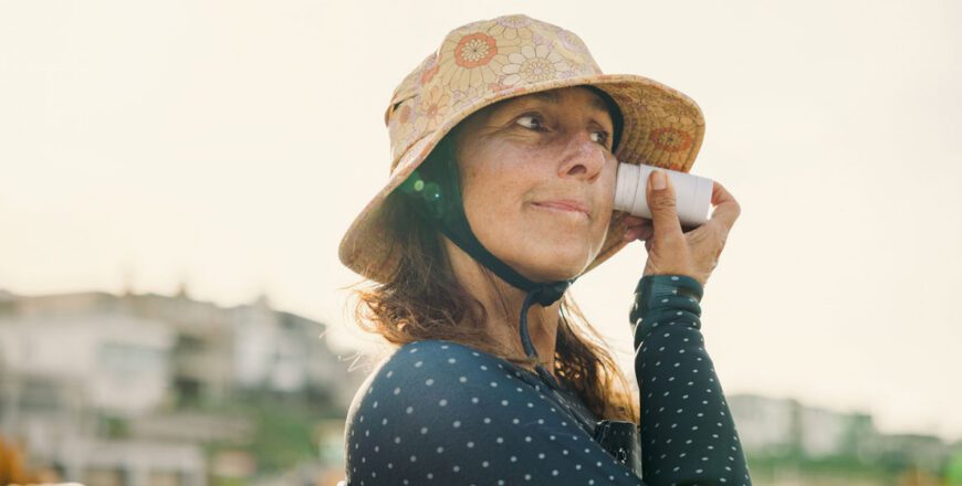 woman-in-a-sun-hat-holding-a-drink-outdoors