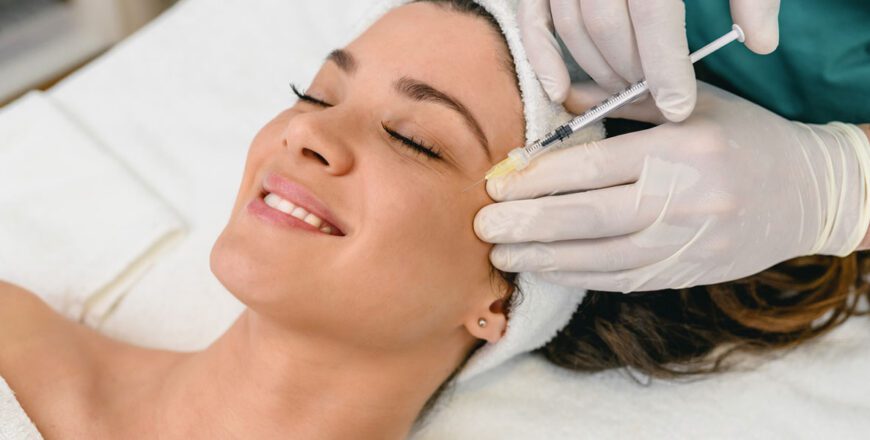 woman-receiving-a-cosmetic-injection-near-her-eye-from-a-gloved-provider