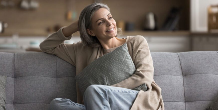 woman-sitting-on-a-couch-with-one-hand-behind-her-head